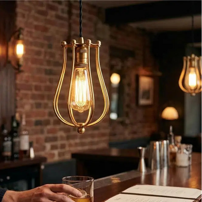 Person holding a glass of whiskey at a bar with warm lighting and a brick wall.