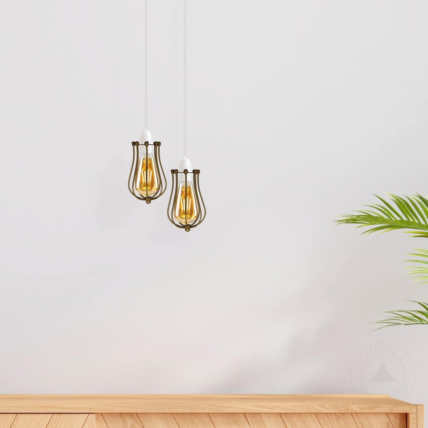 Two hanging pendant lights with gold accents on a white wall.