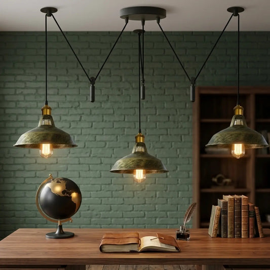 Three pendant lights hanging above a desk with a globe, open book, and inkwell against a brick wall.