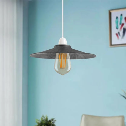 Modern pendant light with a black shade against a light blue wall.